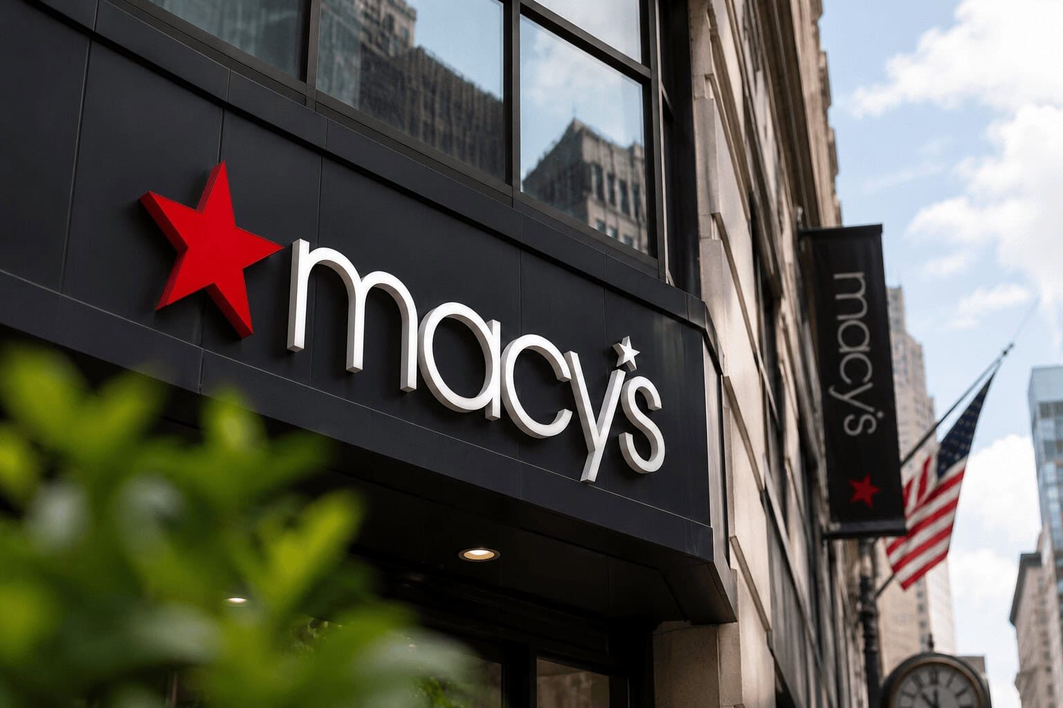 Macy's flagship storefront with the iconic red star logo against a dark facade, framed by Manhattan towers